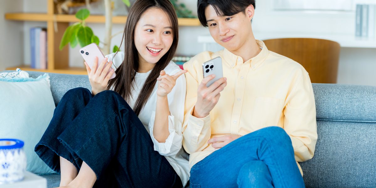 スマホでオンライン内見をするカップル