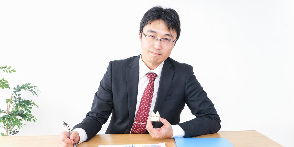 住宅模型を持つ不動産会社の担当者